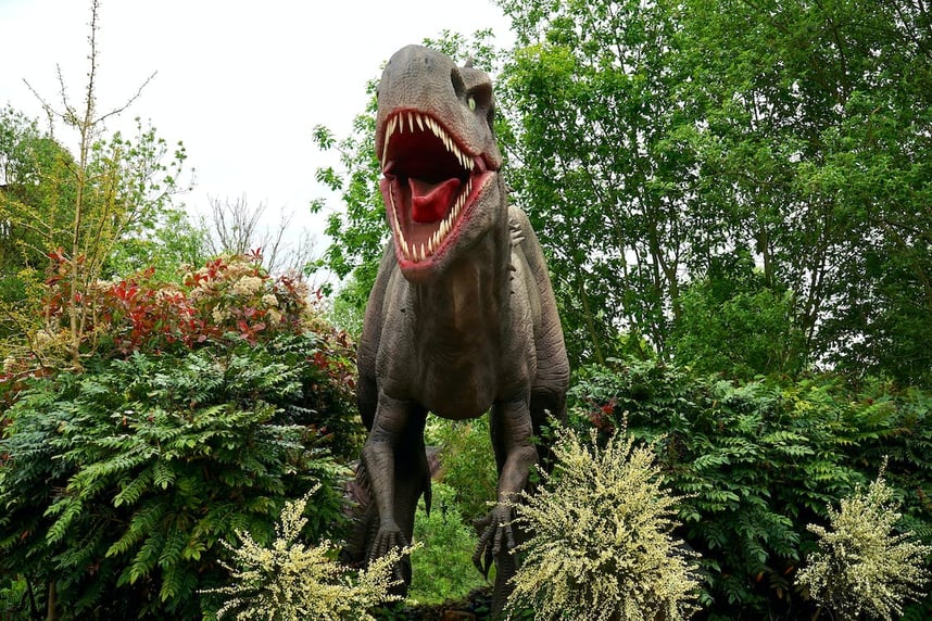 scary dinosaur running through bushes